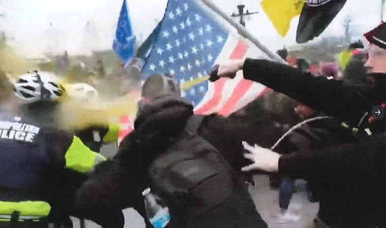 Andrew Taake, right, seen attacking officers with chemical spray on Jan. 6, 2021. 