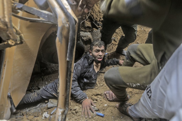 A survivor is pulled out of the rubble after a strike in Rafah, southern Gaza, on Dec. 20, 2023.