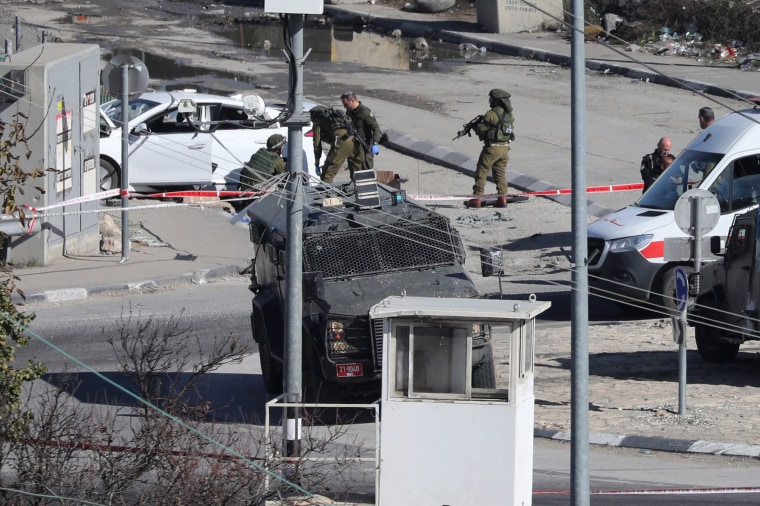 Israeli forces cordon off an area after a Palestinian driver was shot by Israeli soldiers as he reportedly attempted a ramming attack at the Beit Einun junction, north of the West Bank city of Hebron on Dec. 20, 2023. 