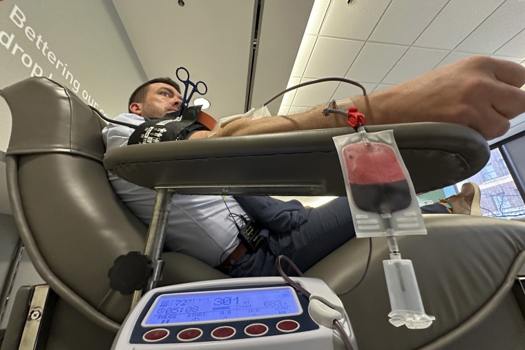 Aaron Posey, a Bloodworks Northwest executive, donates blood at the blood center's Seattle headquarters on Dec. 14, 2023. 
