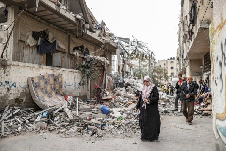 People walk through a destroyed Gaza street 