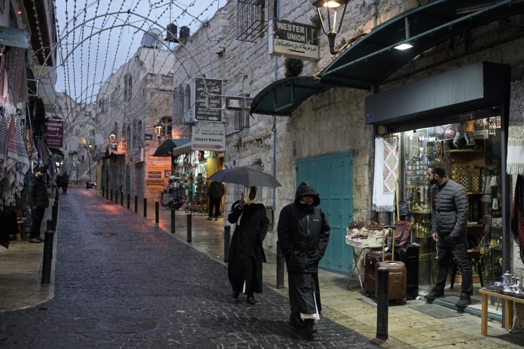 People walk by shops near the Church of the Nativity, in Bethlehem
