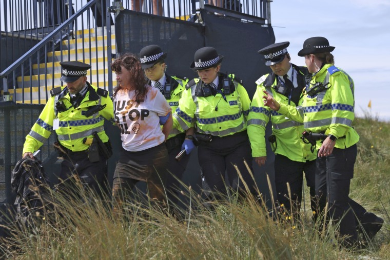 A "Just Stop Oil" protester is led away by police and security at the British Open Golf Championships at the Royal Liverpool Golf Club on July 21, 2023. 