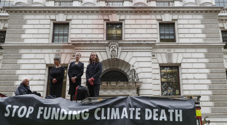 Extinction Rebellion climate activists stand on a fire engine outside the Treasury building in London on Oct. 3, 2019 after activists sprayed fake blood on the building.