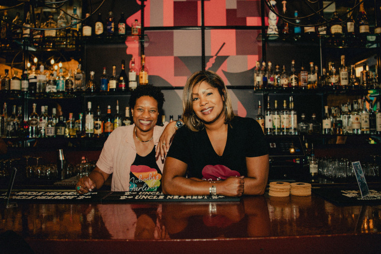 Angela Barnes and Renauda Riddle pose for a photo behind the bar.