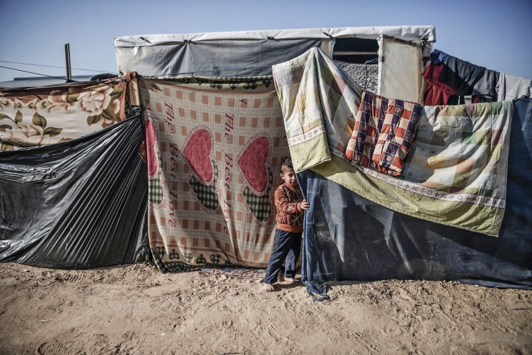 A Palestinian boy stands near a makeshift tent in Rafah, Gaza, on Dec. 26, 2023.