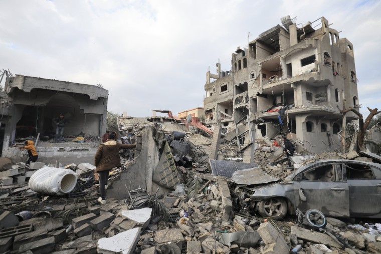 Palestinians inspect the damage at the Al-Maghazi refugee camp after an Israeli strike