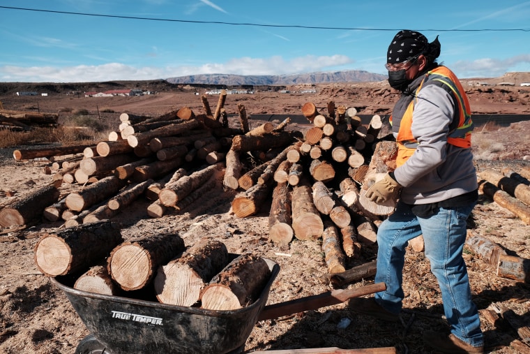 A member of the Navajo community loads wood for delivery to homes on a reservation in Cameron, Ariz., in 2021.  The wood was accessed through the National Forest Foundation's Wood for Life initiative. 