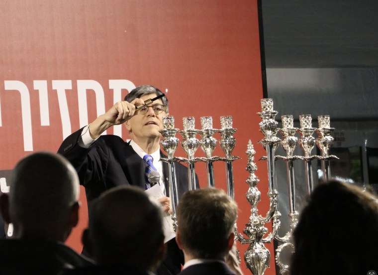 U.S. Ambassador to Israel Jack Lew lights the first candle of a menorah in honor of those still held hostage by Hamas on the first night of Hanukkah in Tel Aviv.