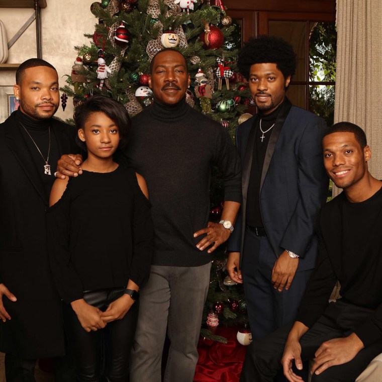 Christian Murphy posing at the holidays with several of his siblings and his father, Eddie Murphy.