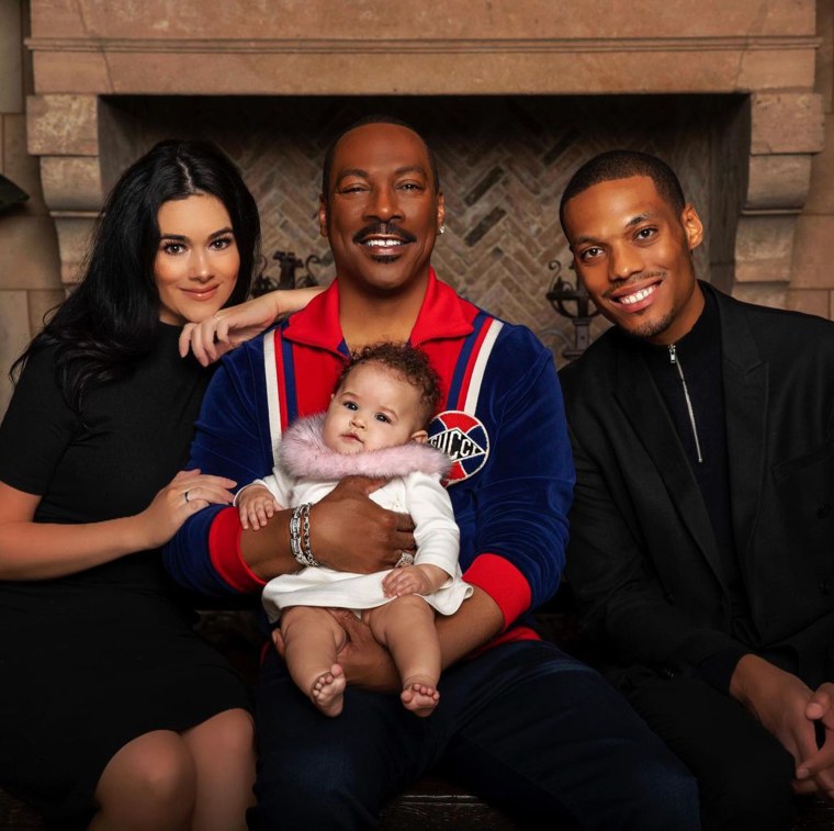Myles and Carly Murphy pose with Eddie Murphy and their daughter, Evie.