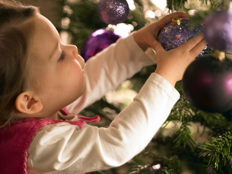 A child decorating a Christmas tree