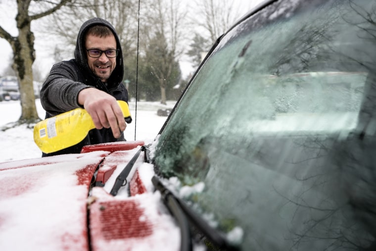 Brian Elsey cleans off his boss's car before heading home in Portland, Ore., on Jan. 13, 2024. 