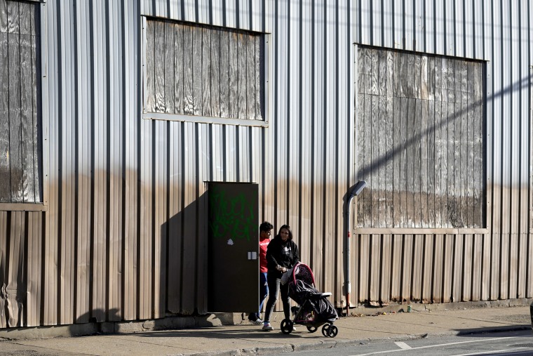 A couple and a young child leave an immigrant shelter in the Pilsen neighborhood of Chicago, on Dec. 19, 2023. 