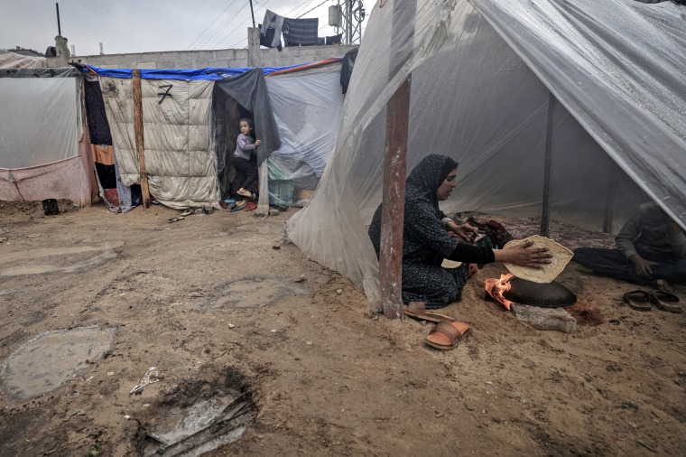 A Palestinian woman makes bread at a makeshift camp housing displaced Palestinians in Rafah in the southern Gaza Strip, on Jan. 2, 2024.