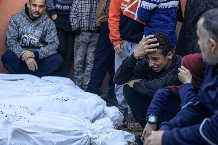 A relative mourns over the bodies of the Salah and Abu Hatab families, killed when the tent where they were sheltering was hit by Israeli bombardment, at the morgue of the Nasser medical center in Khan Yunis
