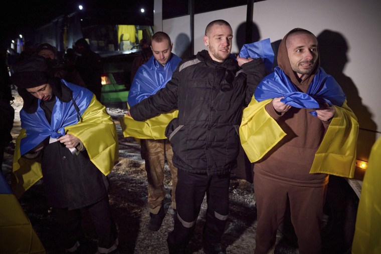Ukrainian prisoners of war hold national flags after a prisoner exchange near Sumy, Ukraine