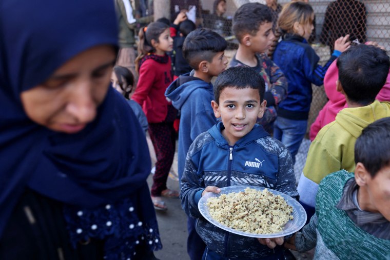 Displaced Palestinians who fled Khan Younis line up for food in Rafah, southern Gaza, on Jan. 4, 2024.