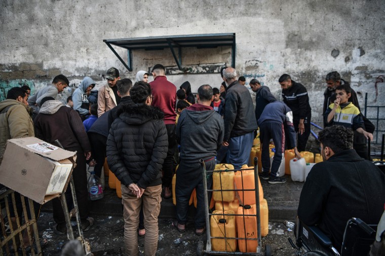 Palestinians wait in line to get clean water from a fountain in Rafah, southern Gaza on Jan. 3, 2024. 