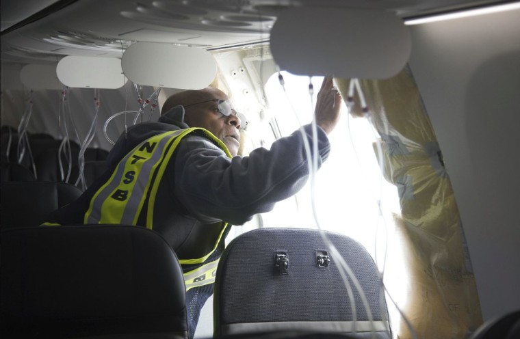 NTSB Investigator-in-Charge John Lovell examines the fuselage plug area of Alaska Airlines Flight 1282 on Sunday, Jan. 7, 2024, in Portland, Ore. (National Transportation Safety Board via AP)