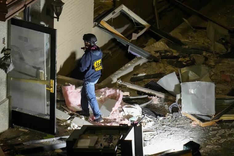 An official surveys an area near the back entrance to the Sandman Signature hotel following an explosion, in Fort Worth, Texas