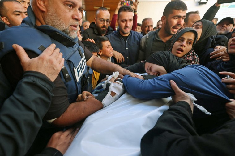 The widow of Al Jazeera journalist Hamza Wael Dahdouh and his father, Wael Al-Dahdouh, Al Jazeera's bureau chief in Gaza, mourn over his body during his funeral in Rafah in the Gaza Strip on Jan. 7, 2024. 