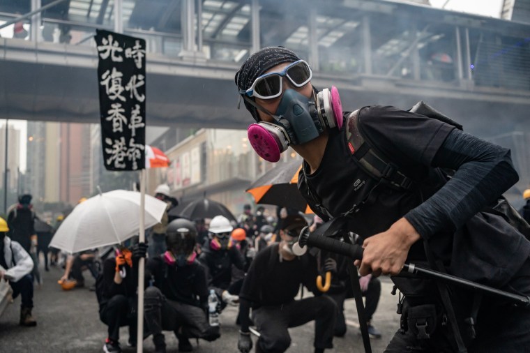 Protesters throw a brick at police during a clash at an anti-government rally in Tsuen Wan district in Hong Kong,