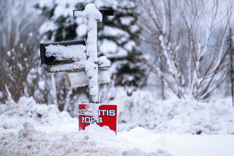 Snow covers a sign for Florida Gov. Ron DeSantis in Davenport, Iowa, on Jan. 11, 2024.