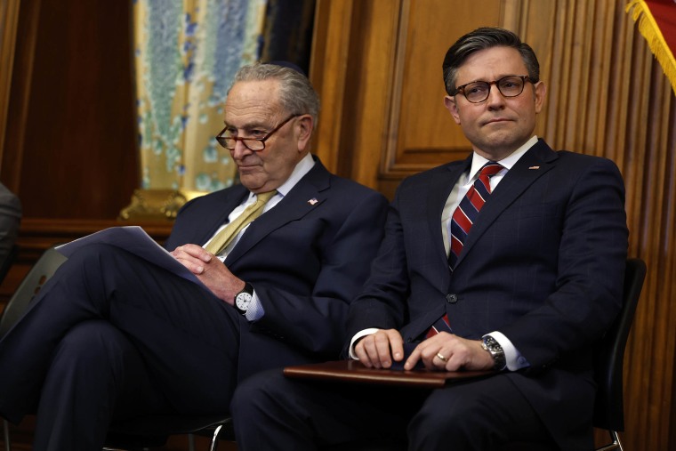 Senate Majority Leader Chuck Schumer (D-NY) and Speaker of the House Mike Johnson (R-LA) listen to remarks at the Capitol Building on Dec. 12, 2023.