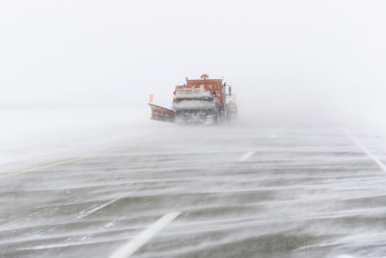 A snow plow moves along the snow-streaked, eastbound lane of U.S. Highway 20 during a blizzard near Holstein, Iowa, on Saturday. 