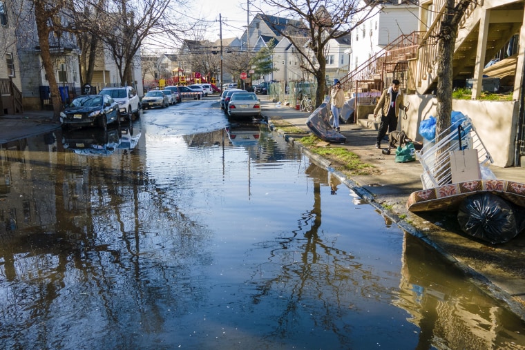 Water overflows from the Passaic River after heavy rain floods a neighborhood in Paterson, N.J., on Friday.