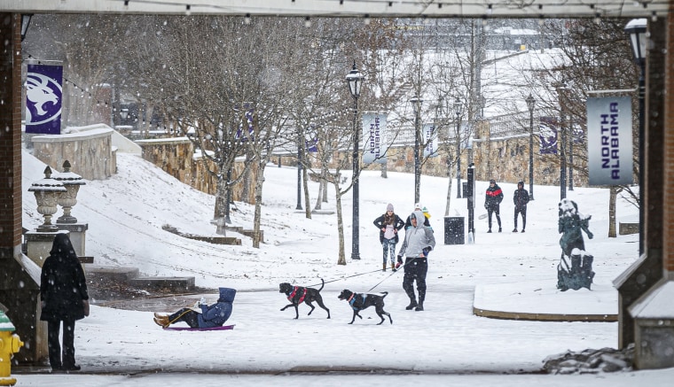 People walk in the snow at the University of North Alabama on Monday in Florence, Ala. 