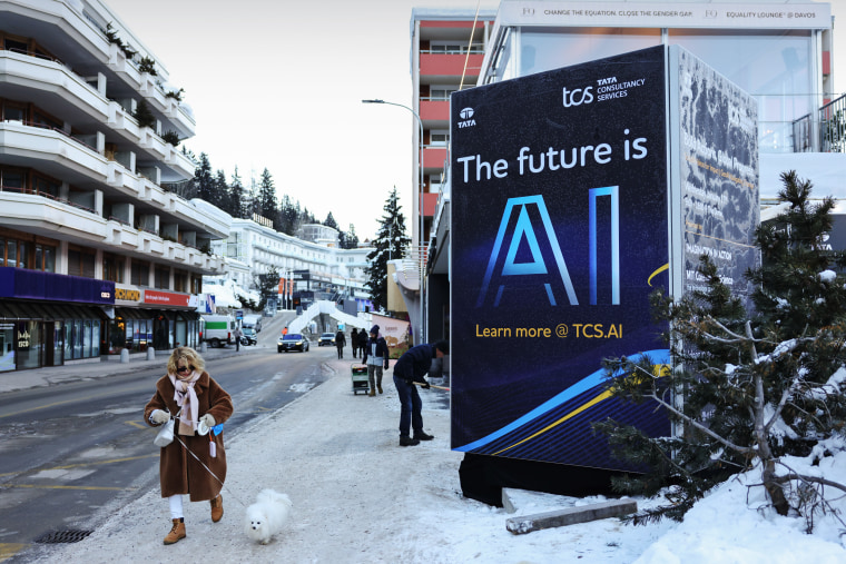 A pedestrian walks past the TATA pop up store with a poster reading "The Future is AI" ahead of the World Economic Forum  in Davos, Switzerland, on Sunday, Jan. 14, 2024. 