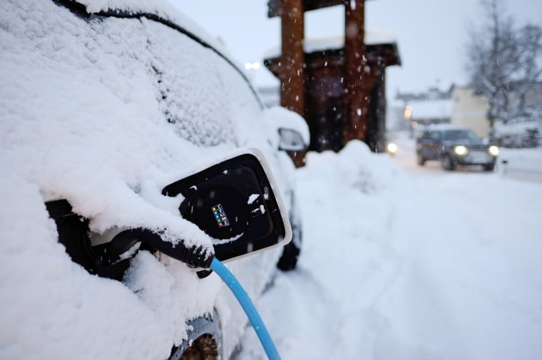 An electric vehicle charges during a snowstorm in Flachau, Austria. in 2020.