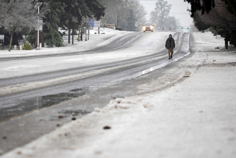 A man walks on the road in the snow on Wednesday, Jan. 17, 2024, in Tigard, Ore. 