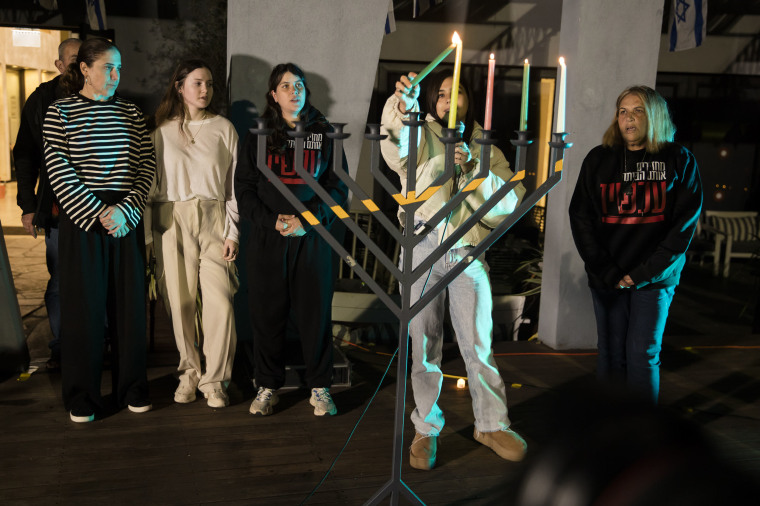 Released hostages, Hen Goldstein-Almog and her daughter Agam (L) take part at a Kfar Aza community event on the fourth night of Hanukkah on December 10, 2023 in Shefayim, Israel. Chen Goldstein-Almog and three of her four children were released during in November weeklong ceasefire.