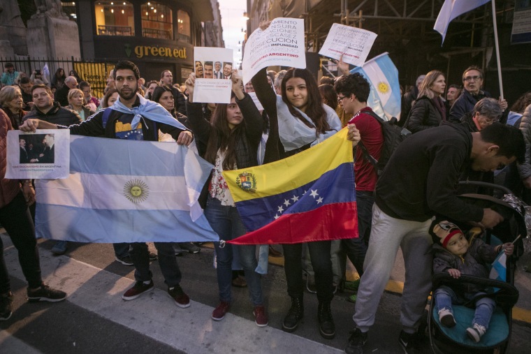 Venezuelan immigrants hold an Argentine and Venezuelan flags during a march in support of President Mauricio Macri in Buenos Aires, Argentina