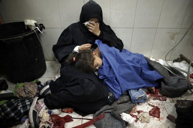 A Palestinian woman cries as she sits next to her wounded girl at the Nasser hospital in Khan Younis, southern Gaza, on Monday, Jan. 22, 2024. 