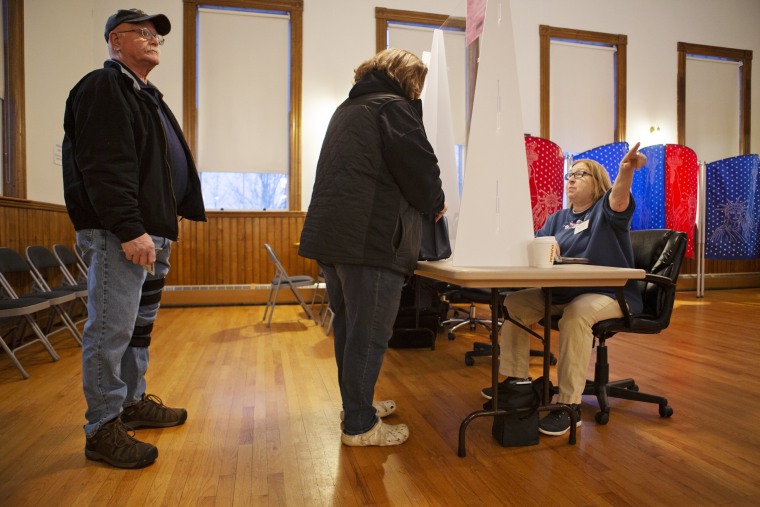 Ballot clerk Kathy Brooks directs a voter in New Hampshire's primary at the Academy in Gilmanton on Jan. 23, 2024.