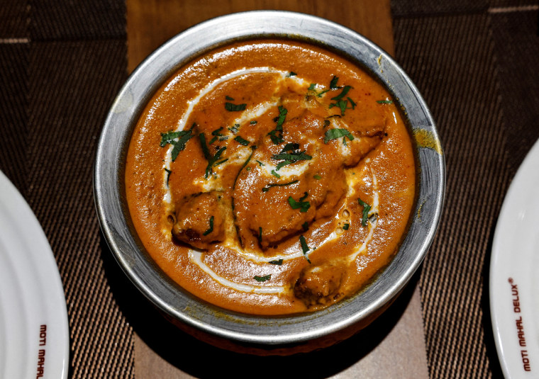 A freshly prepared butter chicken dish is placed on a table