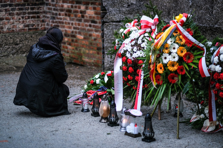 Image: A visitor pays their respects at the Auschwitz-Birkenau former German Nazi concentration and extermination camp