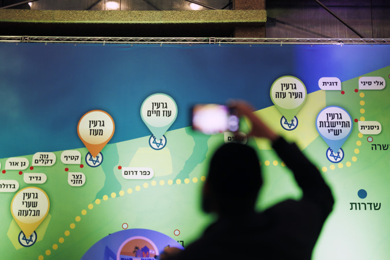 An attendee takes a picture near a map suggesting a vision for Israeli settlements in Gaza at the conference in Jerusalem on Sunday.