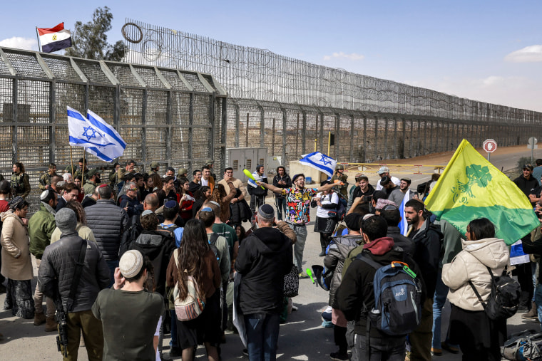 Israeli demonstrators gather by the border fence with Egypt at the Nitzana border crossing in southern Israel on Jan. 30, 2024, as they attempt to block humanitarian aid trucks from entering into Israel on their way to the Gaza Strip.