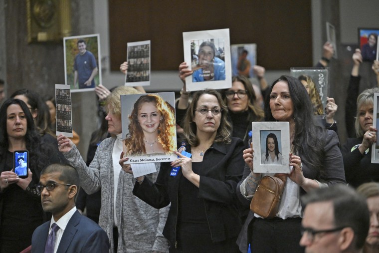 Relatives hold pictures of children before the start of the "Big Tech and the Online Child Sexual Exploitation Crisis," on Jan. 31, 2024.