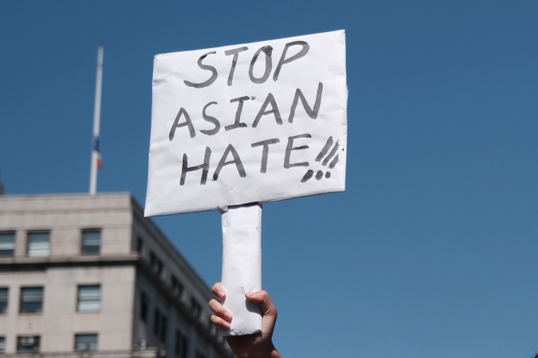 A protester holds a sign that reads  "Stop Asian Hate."