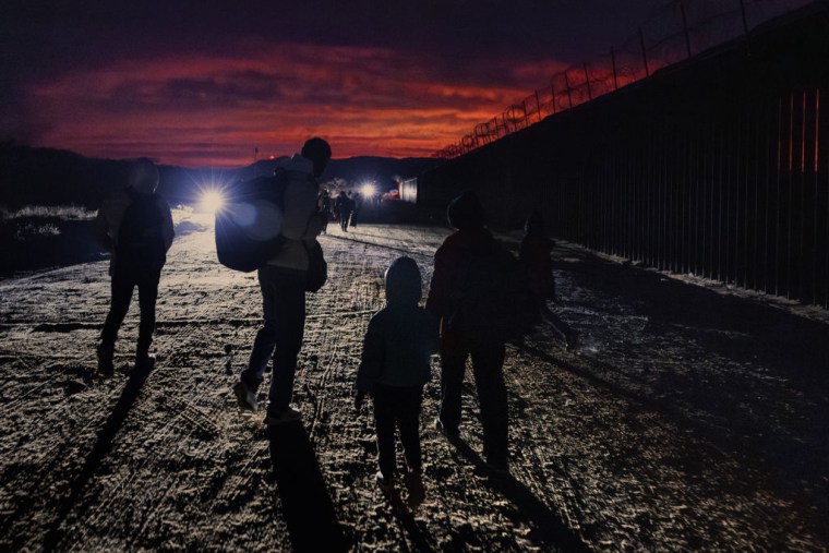 Migrantes caminan a lo largo de la frontera entre México y Estados Unidos el 3 de enero de 2024 ern Jacumba Hot Springs, en San Diego, California. 