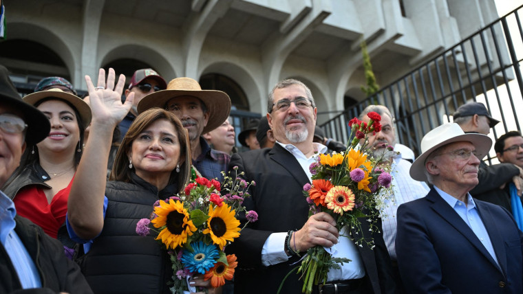 El presidente electo de Guatemala Bernardo Arévalo y la vicepresidenta electa Karin Herrera sostienen flores durante un evento en diciembre de 2023