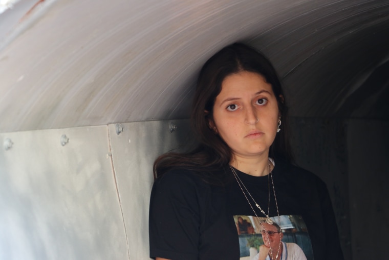 Ella Ben Ami, 23, walks through a "tunnel" set up in Tel Aviv today to re-create the conditions hostages held by Hamas, including her father, have faced.