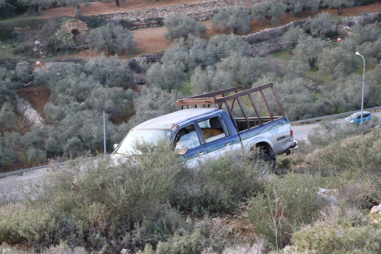 The truck in which Tawfic Hafeth Abdel Jabbar was shot dead sits over Highway 60 in the occupied West Bank on Saturday.