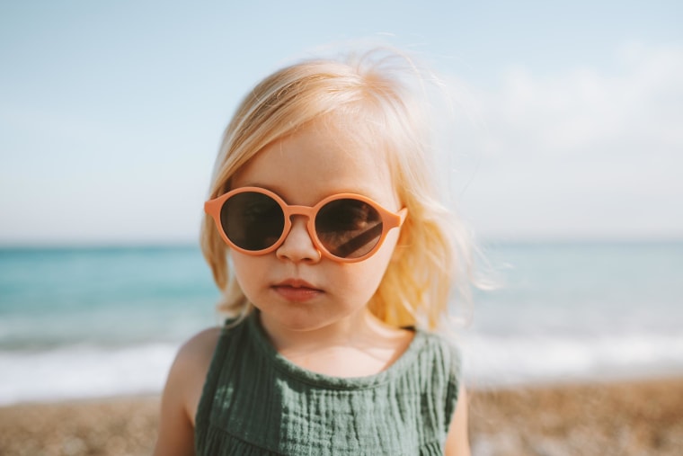 Child girl traveling walking on beach 3 years old toddler in sunglasses baby portrait looking at camera family vacations trip